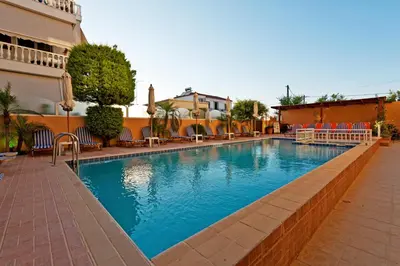 a swimming pool at a hotel with chairs around it at Alea Hotel Apartments in Ialyssos