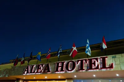 a hotel sign with flags on top of a building at Alea Hotel Apartments in Ialyssos