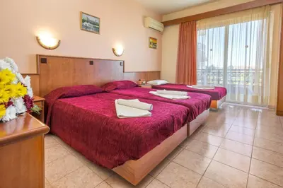 a hotel room with two beds with red sheets at Alea Hotel Apartments in Ialyssos