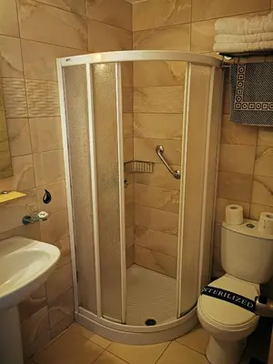 a bathroom with a shower with a toilet and a sink at Europa Hotel in Rhodes Town