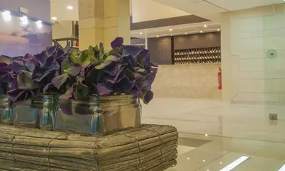 a vase filled with purple flowers sitting on a table at Europa Hotel in Rhodes Town