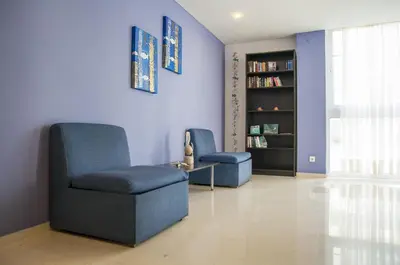 a living room with two chairs and a book shelf at Europa Hotel in Rhodes Town