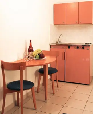 a kitchen with a table with fruit and a bottle of wine at Europa Hotel in Rhodes Town