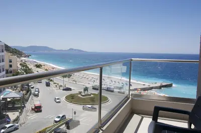 a balcony with a view of a beach and the ocean at Europa Hotel in Rhodes Town