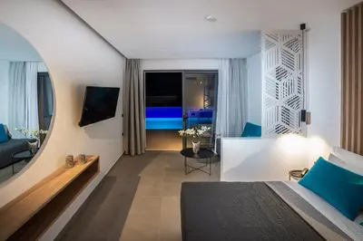 a bedroom with a bed and a living room at Zoes Hotel & Suites in Faliraki