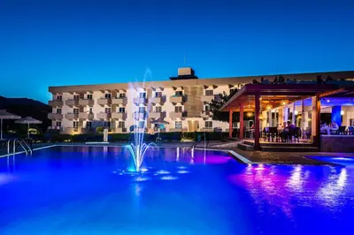 a fountain in front of a hotel at night at Zoes Hotel & Suites in Faliraki