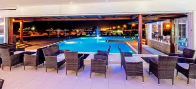 a resort with a swimming pool at night at Zoes Hotel & Suites in Faliraki