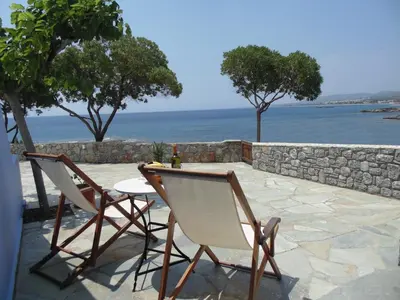 a patio with two chairs and a table with a view of the ocean at Paraktio Beach Apartments in Kiotari