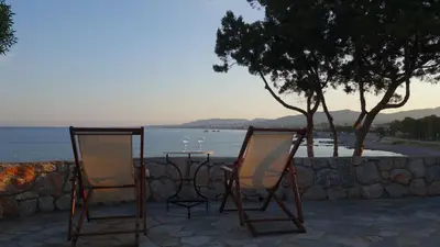 two chairs and a table in front of the ocean at Paraktio Beach Apartments in Kiotari