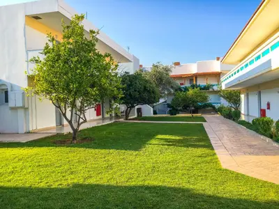 a courtyard of an apartment building with a lawn at Lydia Maris Resort & Spa in Kolimbia