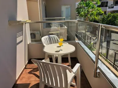 a small balcony with a white table and two chairs at Caravel Hotel Apartments in Ixia