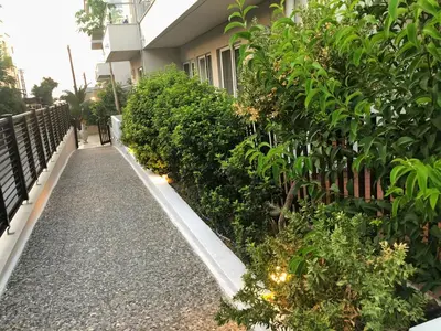 a walkway in front of a building with plants at Caravel Hotel Apartments in Ixia