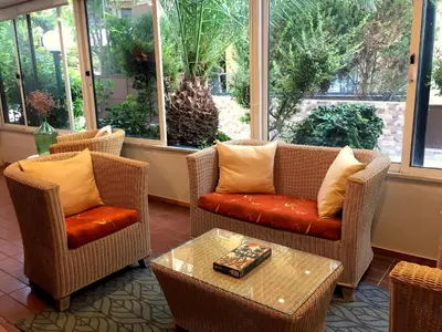 a lobby with chairs and a table and windows at Caravel Hotel Apartments in Ixia