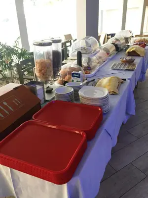 a long blue table with plates and food on it at Caravel Hotel Apartments in Ixia