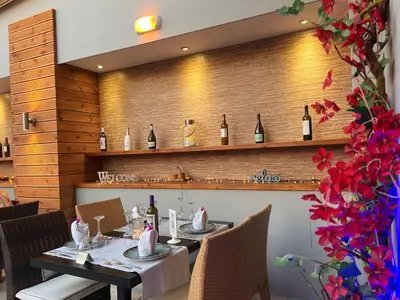a dining room with a table with bottles of wine at Caravel Hotel Apartments in Ixia