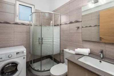 a bathroom with a washing machine and a sink at Amazing Summer Villa in Kolimbia