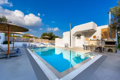 a swimming pool with blue water in a villa at Amazing Summer Villa in Kolimbia