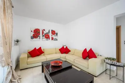 a living room with a couch and red pillows at Amazing Summer Villa in Kolimbia