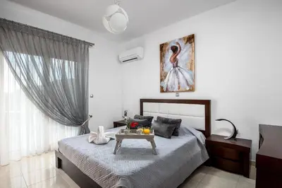 a bedroom with a bed with a table in it at Amazing Summer Villa in Kolimbia