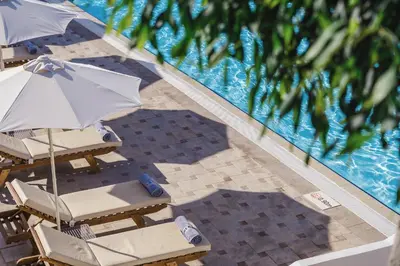 an overhead view of chairs and umbrellas next to a swimming pool at Lindos Village Resort & Spa - Adults Only in Líndos