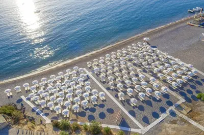 an overhead view of a beach with a lot of umbrellas at Lindos Village Resort & Spa - Adults Only in Líndos