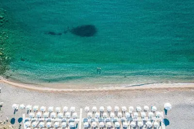 an overhead view of a beach with chairs and the ocean at Lindos Village Resort & Spa - Adults Only in Líndos
