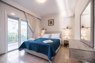 a bedroom with a bed and a large window at Casa Stergos 2apts in Archangelos