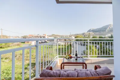 a balcony with a couch and a table at Casa Stergos 2apts in Archangelos