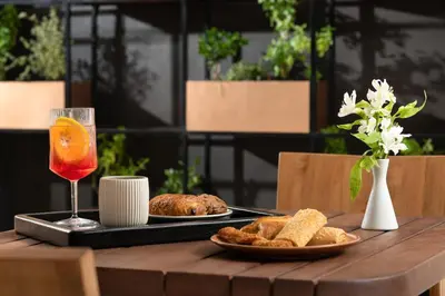 a table with a plate of food and a drink at Electra Palace Rhodes - Premium All Inclusive in Ialyssos
