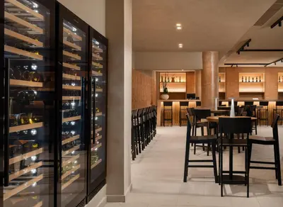 a dining room with a table and chairs and wine racks at Electra Palace Rhodes - Premium All Inclusive in Ialyssos