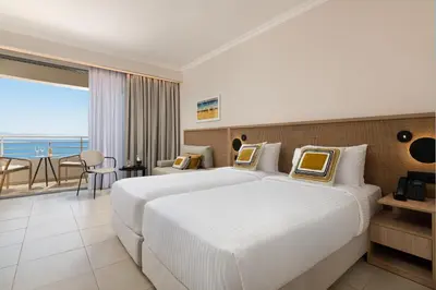a hotel room with two beds and a balcony at Electra Palace Rhodes - Premium All Inclusive in Ialyssos