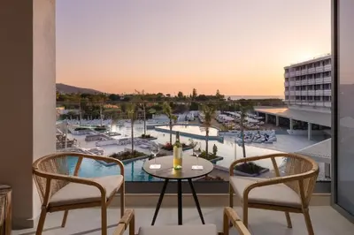 a balcony with a table and chairs and a view of a marina at Electra Palace Rhodes - Premium All Inclusive in Ialyssos