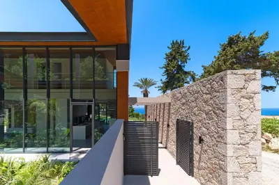 a house with a stone wall and a stairway at Villa Casa Palmera in Ixia
