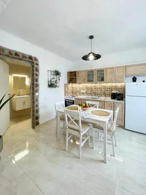 a kitchen with a white table and white appliances at LA Casa Di Lusso N3 - Adults Only in Kolimbia