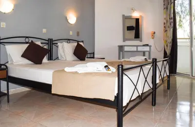 a bedroom with a large bed with white sheets at White Palace Studios in Faliraki