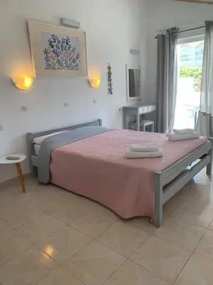 a bedroom with a large bed with two towels on it at White Palace Studios in Faliraki