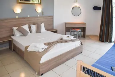 a bedroom with a large bed with towels on it at White Palace Studios in Faliraki