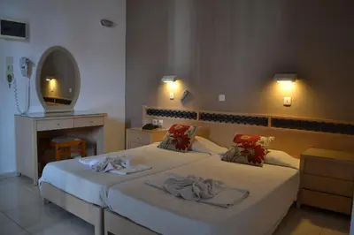 a bedroom with two beds with towels on them at White Palace Studios in Faliraki