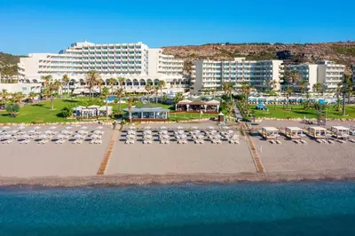 an aerial view of a beach with chairs and buildings at Rodos Palladium Leisure & Wellness in Faliraki