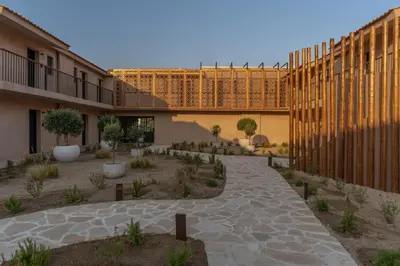 a courtyard of a building with plants and trees at Eleonas Boutique Hotel & Spa - Adults Only in Ialyssos