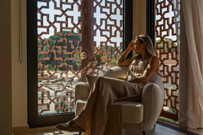a woman sitting in a chair talking on a cell phone at Eleonas Boutique Hotel & Spa - Adults Only in Ialyssos