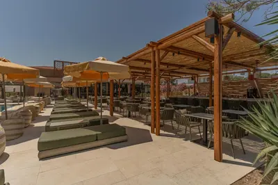 a patio with tables and chairs and umbrellas at Eleonas Boutique Hotel & Spa - Adults Only in Ialyssos