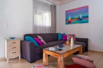 a living room with a couch and a table at Posidonia Luxury Villas Kolympia in Kolimbia