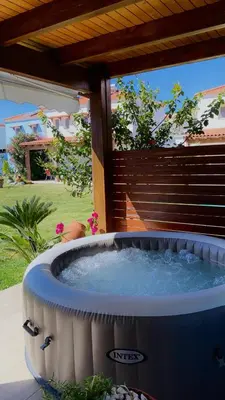 a large hot tub in a yard with a patio at Posidonia Luxury Villas Kolympia in Kolimbia