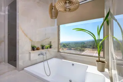 a bath tub in a bathroom with a window at Villa Elios Residence in Asklipiḯon
