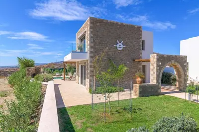 a brick house with a garden in front of it at Villa Elios Residence in Asklipiḯon