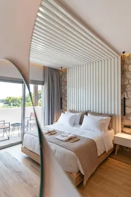 a bedroom with a large bed and a large window at THERETRA PEFKI Seaside in Pefki Rhodes