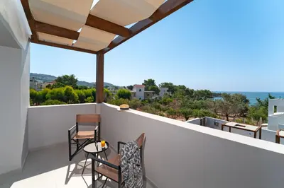 a balcony with chairs and a view of the ocean at THERETRA PEFKI Seaside in Pefki Rhodes