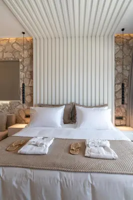 a bedroom with a bed with two towels on it at THERETRA PEFKI Seaside in Pefki Rhodes