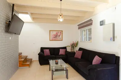 a living room with a black couch and a tv at Renthub Villas at Kolympia in Kolimbia